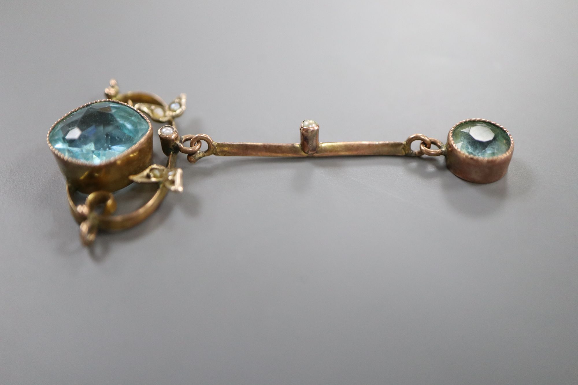 An early 20th century yellow metal, seed pearl and two stone blue topaz set drop pendant, 45mm, gross 2.4 grams.